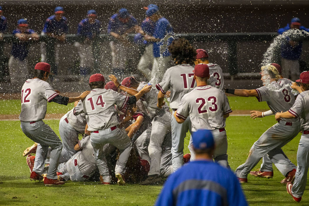 Desert Oasis players celebrate their win over Reno 9-1 during the tie-breaker game of their ...