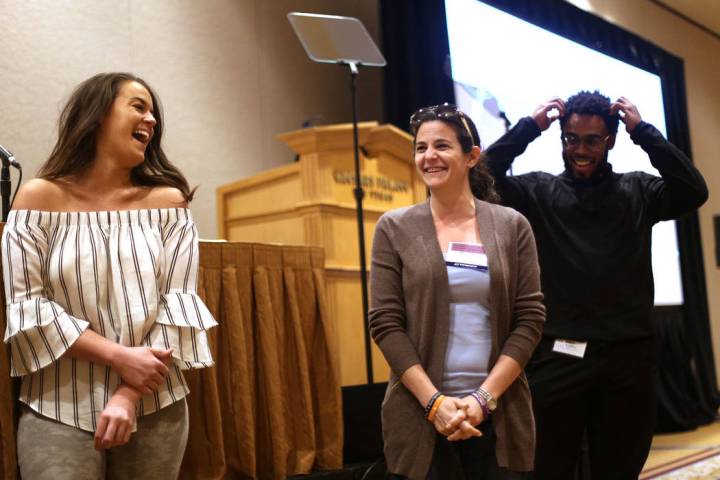 Katie Boer, from left, Melanie Lewis, and Trevor Milazzo laugh while participating in an exerci ...