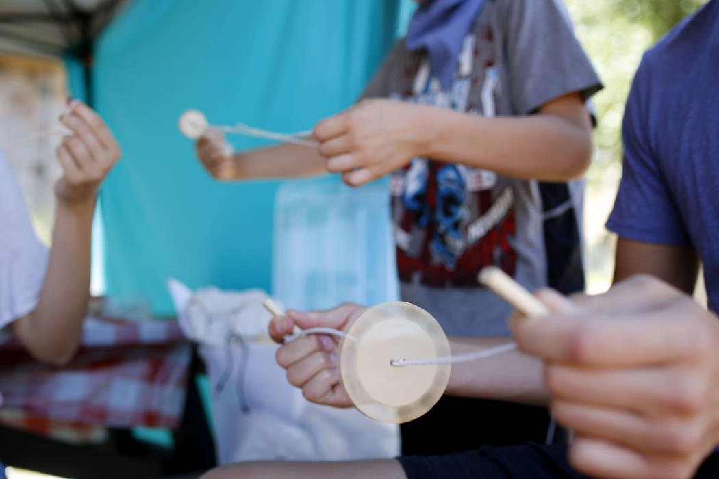 The Talbot siblings make string toys during Pioneer Day at Old Mormon Fort in Las Vegas, Saturd ...