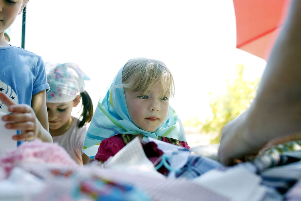 Ava Spencer, 5, watches how to make a pin doll during Pioneer Day at Old Mormon Fort in Las Veg ...