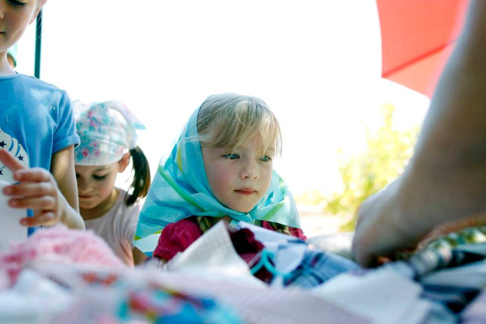 Ava Spencer, 5, watches how to make a pin doll during Pioneer Day at Old Mormon Fort in Las Veg ...