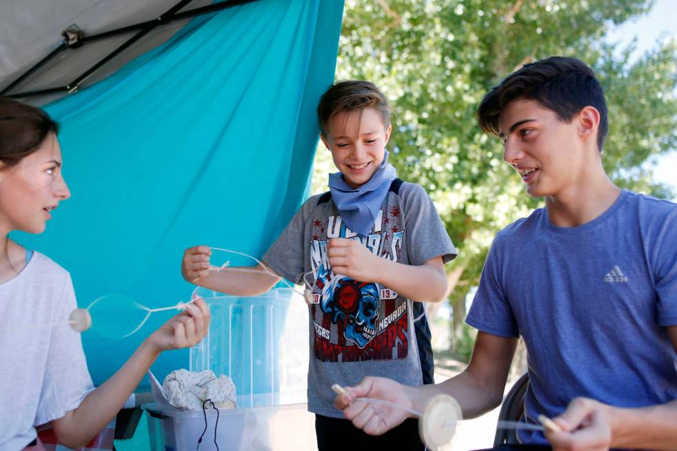 Siblings Cortlin Talbot, 17, left, Ry, 8, and Trayle, 13, play with their string toys during Pi ...