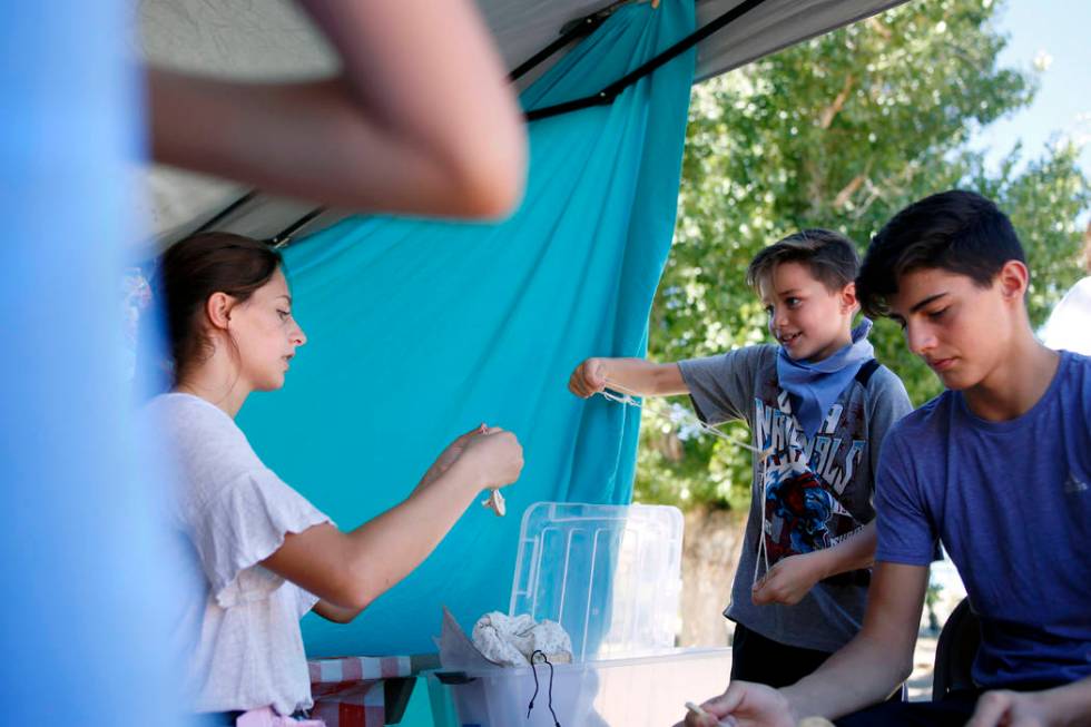 Siblings Cortlin Talbot, 17, left, Ry, 8, and Trayle, 13, play with their string toys during Pi ...