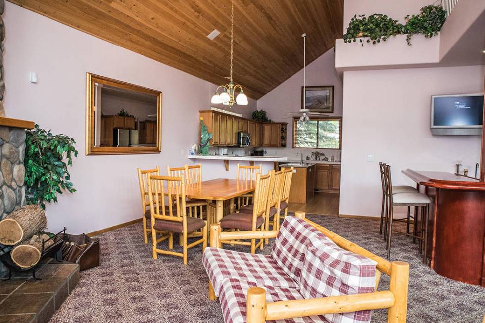 The great room and kitchen is dressed in blond wood log furniture purchased from a furniture ma ...