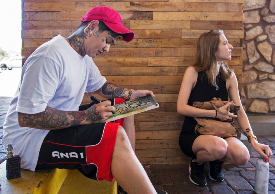 Brandon Morgan, left, with fiancee Danielle Brankin, sketches a memorial message for Max Garcia ...