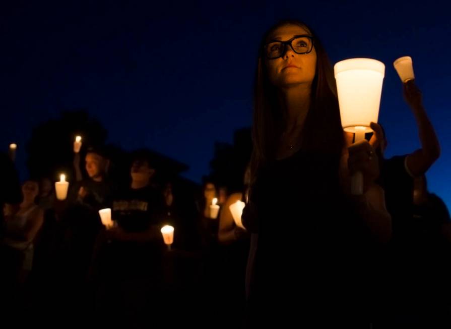 Kimber McMillan, right, holds a candle during a vigil for her friend Max Garcia Monday, July 1, ...