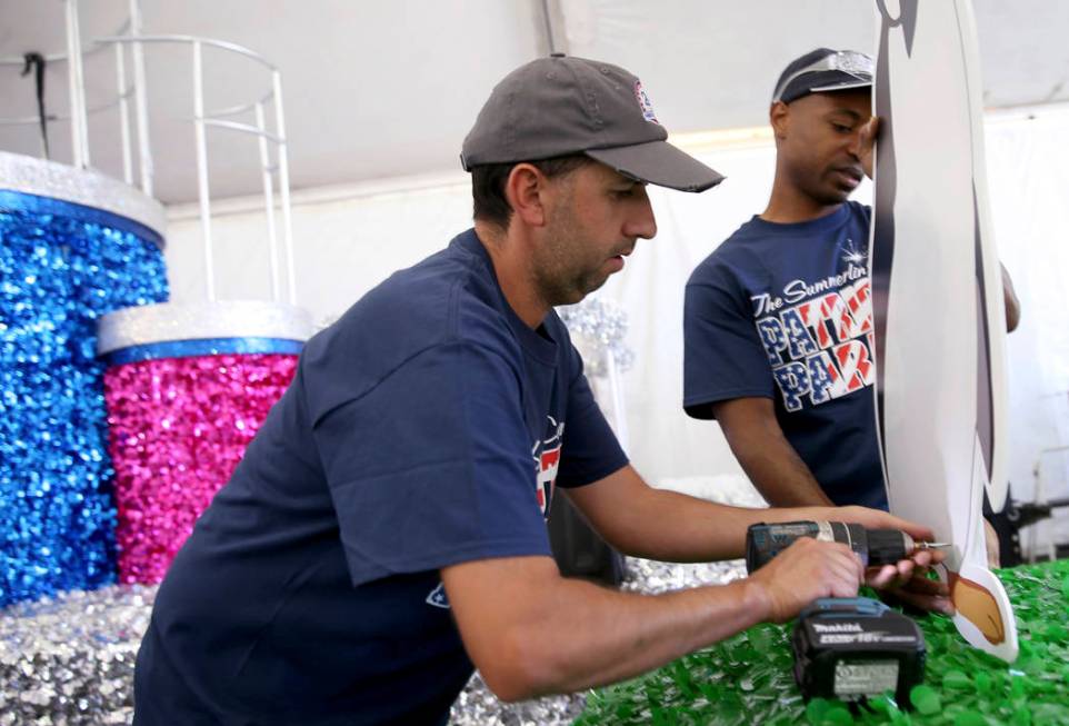 Dave Bailey, left, and Isiah Powell work on the "Mary Poppins Jolly Holiday" float during a med ...