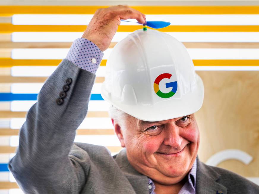 Gov. Steve Sisolak spins the little propeller atop his Google hard hat before a ceremonial dirt ...