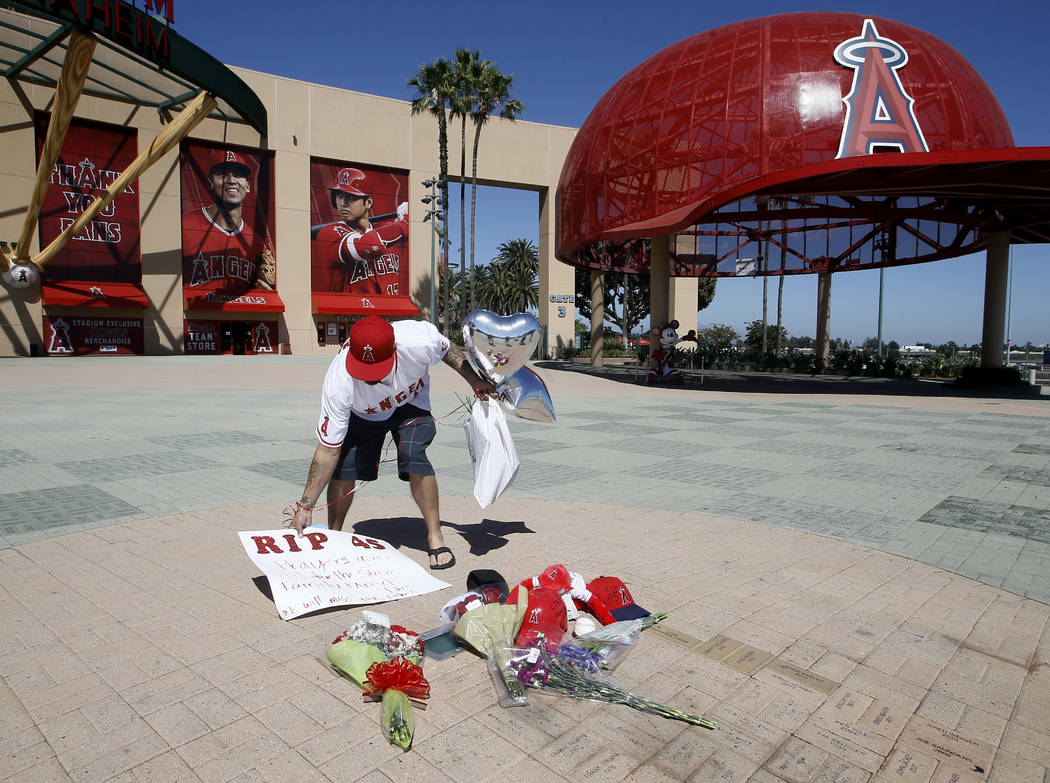 Los Angeles Angels fan Steven Beltran adds to a make-shift memorial at Angels Stadium in Anahei ...