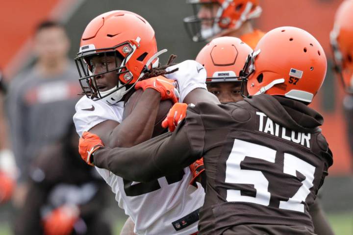 Cleveland Browns running back Kareem Hunt, left, breaks a tackle by linebacker Adarius Taylor d ...