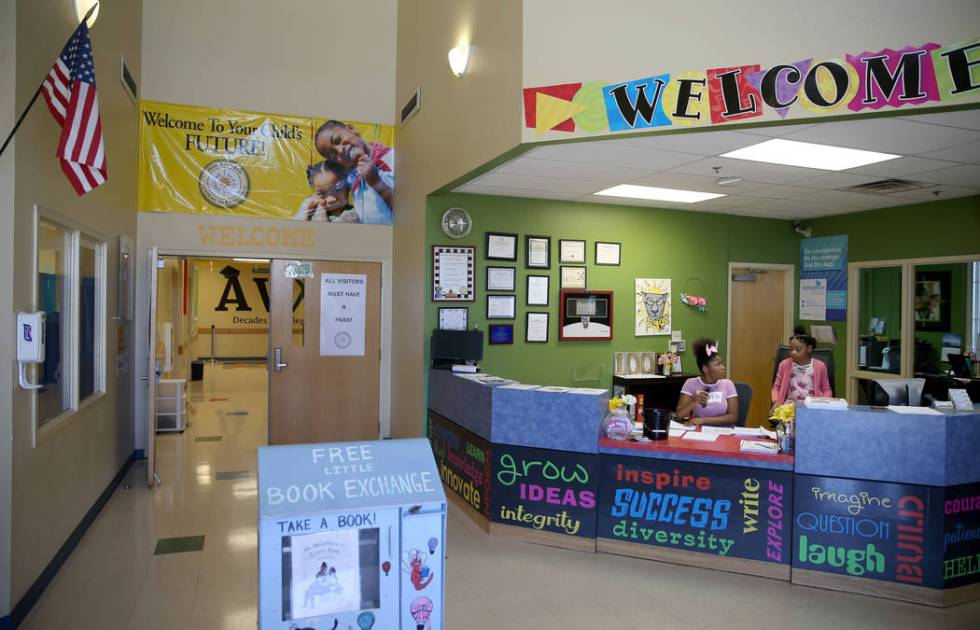 Zariyah West, 12, left, and Rachel Conner, 10, fill in at the front desk during summer camp at ...