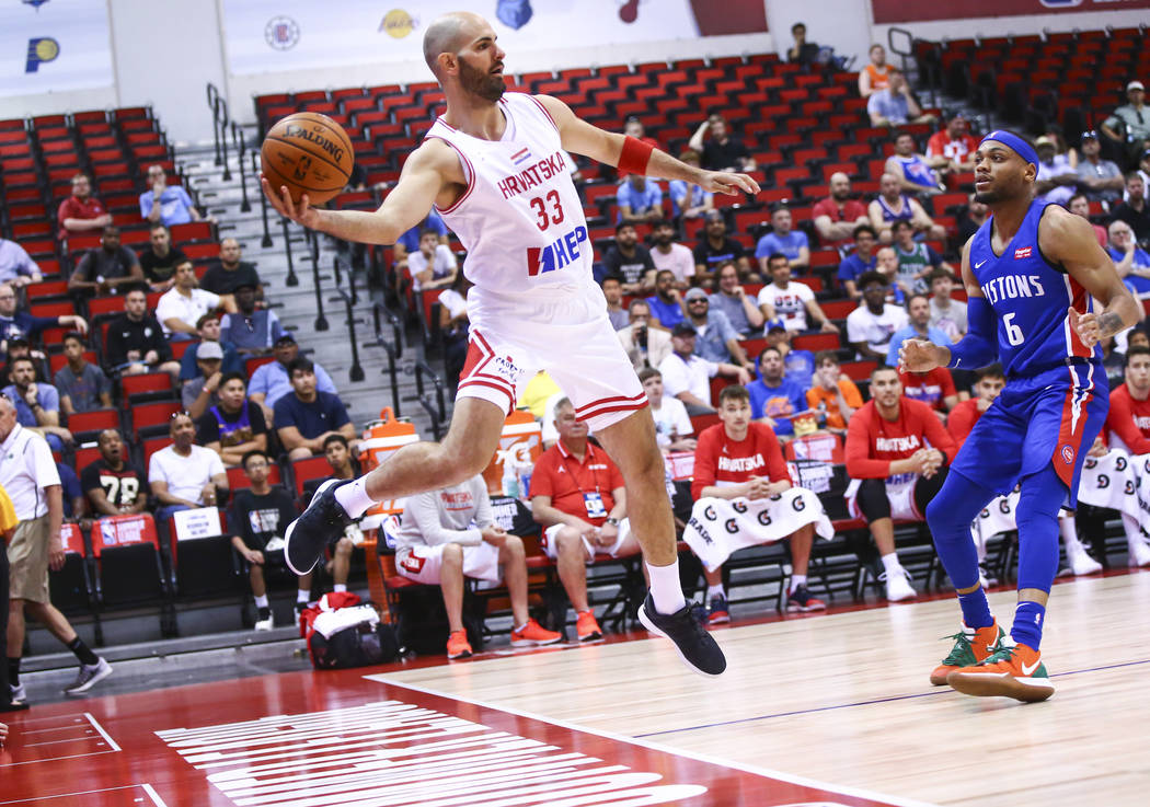 Croatia's Zeljko Sakic (33) jumps to keep the ball in as Detroit Pistons' Bruce Brown (6) looks ...