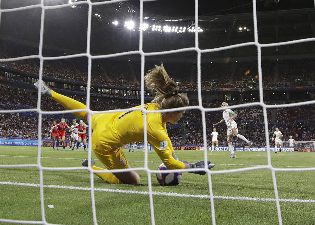United States goalkeeper Alyssa Naeher saves a penalty shot taken by England's Steph Houghton d ...