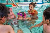 Lorelai Zimring, 5, left, and Ariana Villeda, 4, center, work with swim instructor Shanneal Ocu ...