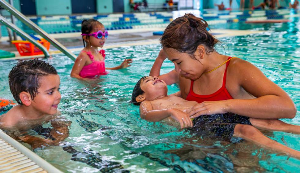 Swim instructor Shanneal Ocular, right, helps her student Stefan Flores, 4, to float during a b ...