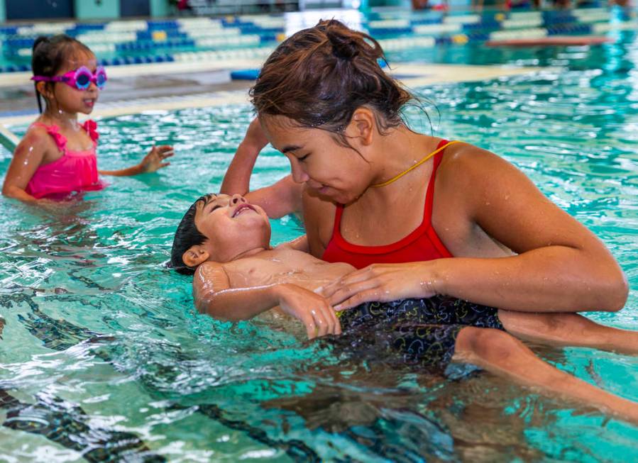 Swim instructor Shanneal Ocular, right, helps her student Stefan Flores, 4, to float during a b ...