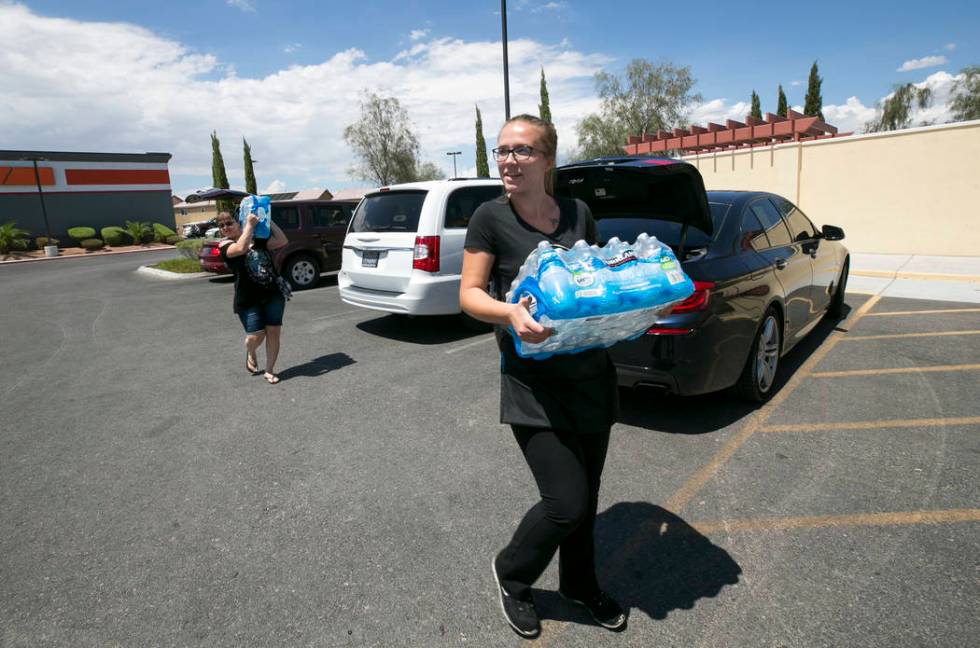 Metro Pizza take out host Sydney Butler, foreground, receives a water donation from Las Vegas r ...