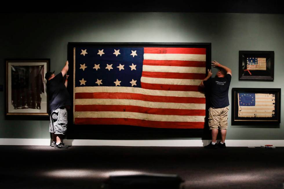 In this Wednesday, June 12, 2019 photo, workmen hang a Federal Era flag as part of the new exhi ...