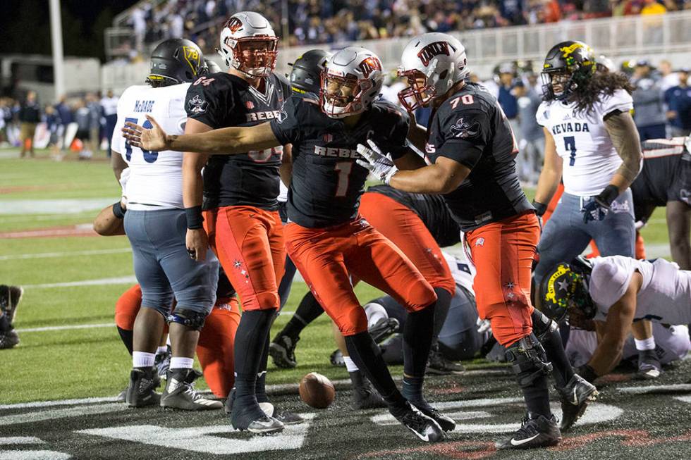 UNLV Rebels quarterback Armani Rogers (1), center, celebrates with offensive lineman Sid Acosta ...