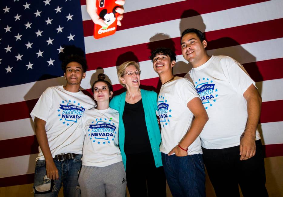 Democratic presidential candidate Sen. Elizabeth Warren, D-Mass., center, poses with members of ...