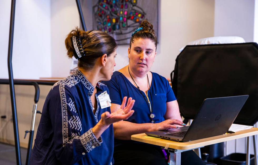 Marketing and Communications Director Nicole Wolf consults with Physical Therapist Sondi Facer ...