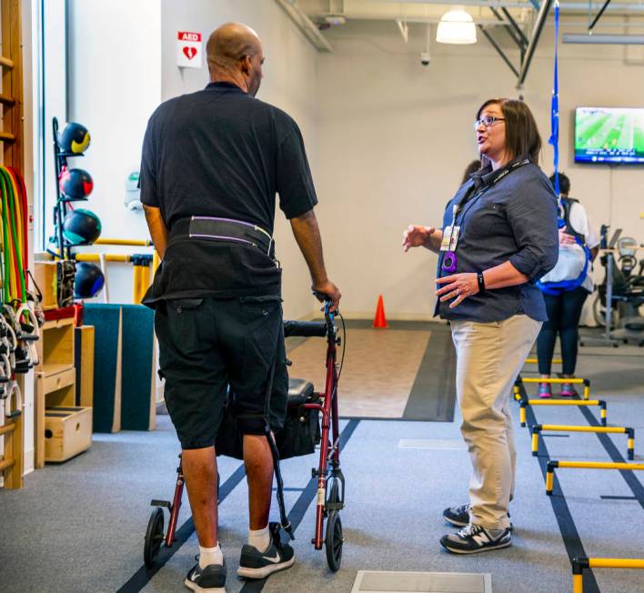 A patient confers with Physical Therapist Christine Ross on a walking exercise within the thera ...