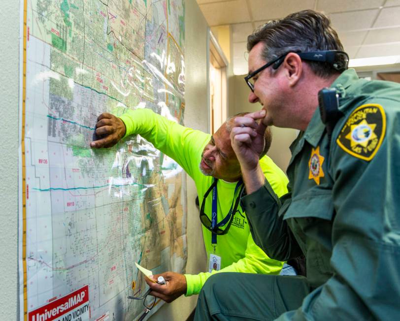 HELP of Southern Nevada Director of Crisis Teams Louis Lacey, left, confers with Metropolitan P ...