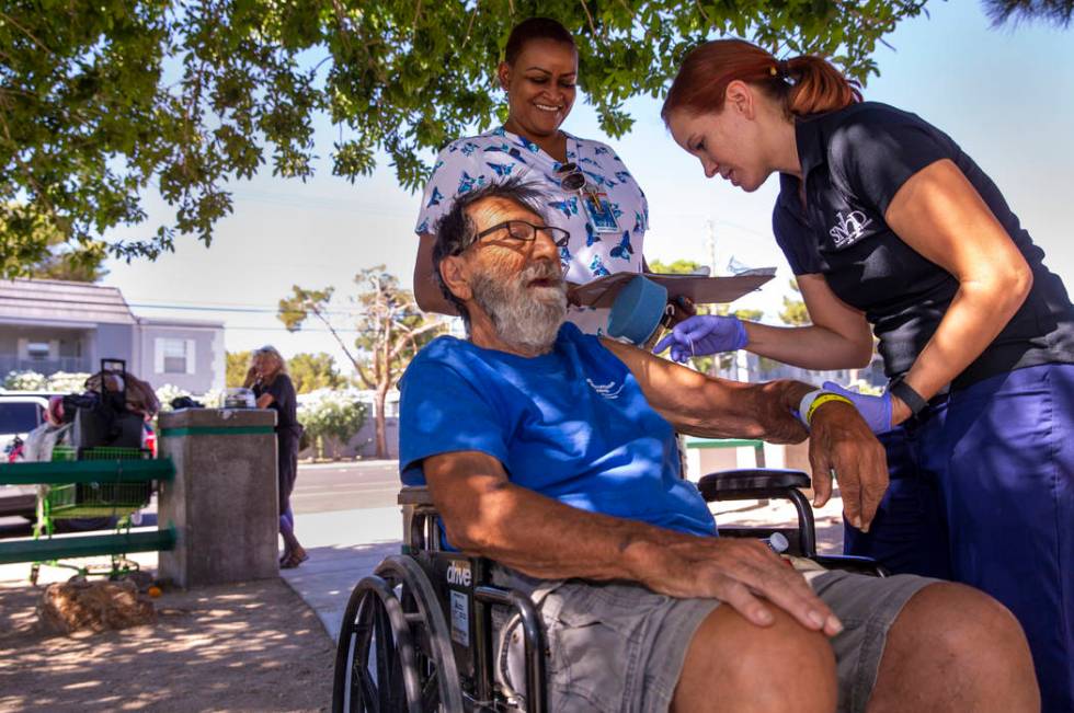 Homeless man Elias Sayegh, left, receives a Hepatitis A shot from Sarah Lugo, Southern Nevada H ...