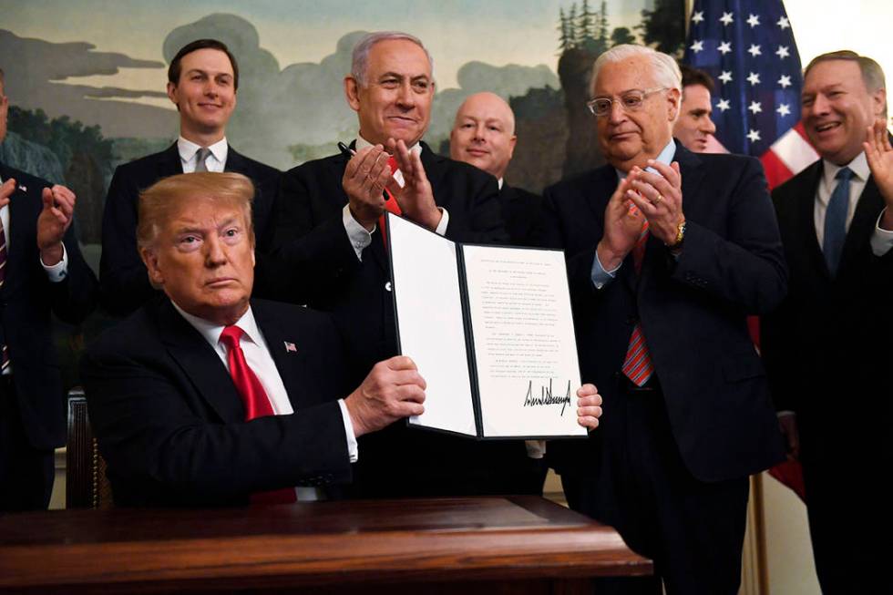 President Donald Trump holds up a signed proclamation recognizing Israel's sovereignty over the ...