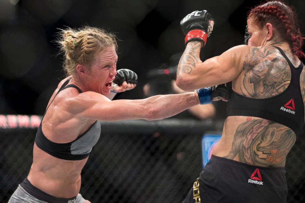 Holly Holm, left, battles Cris "Cyborg" Justino in the UFC 219 women’s feather ...