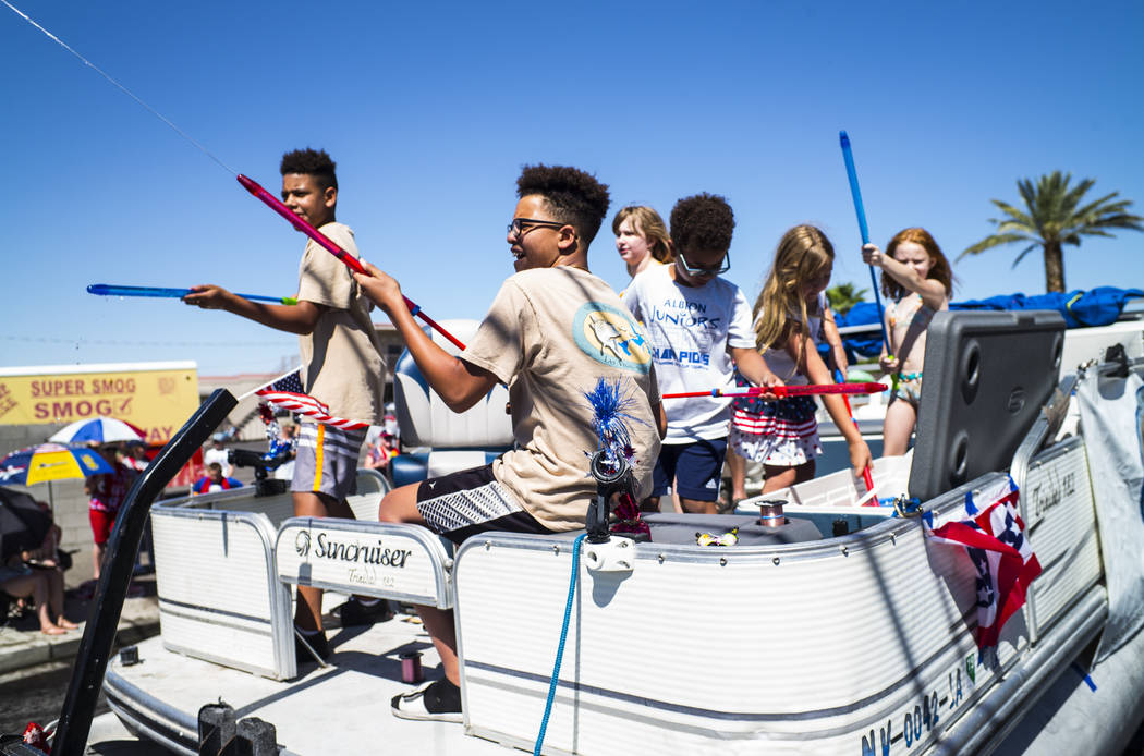 Parade participants supporting the Nevada Striper Club engage in water fights during the parade ...