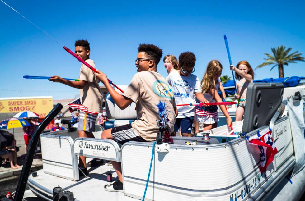 Parade participants supporting the Nevada Striper Club engage in water fights during the parade ...