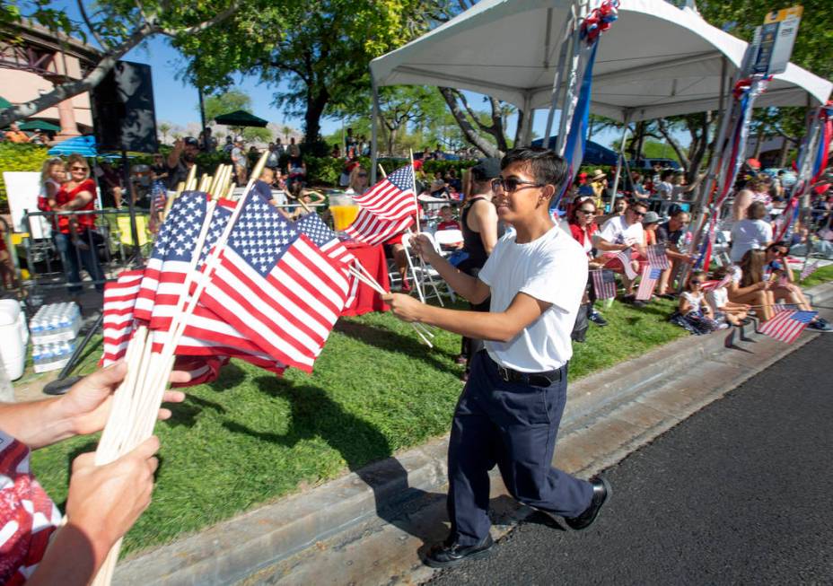 Angel Lemurs, 16, hands out American flags during the 25th annual Summerlin Council Patriotic P ...