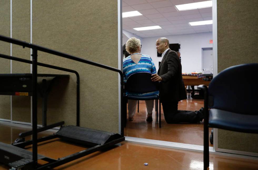 Democratic presidential candidate Sen. Cory Booker, right, speaks with Liz Geffon at a Veterans ...