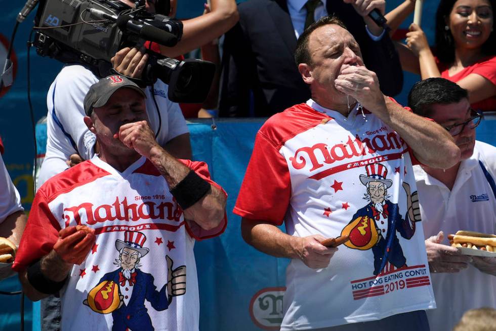 Geoffrey Esper, left, and Joey Chestnut, right, compete during the men's competition of Nathan' ...