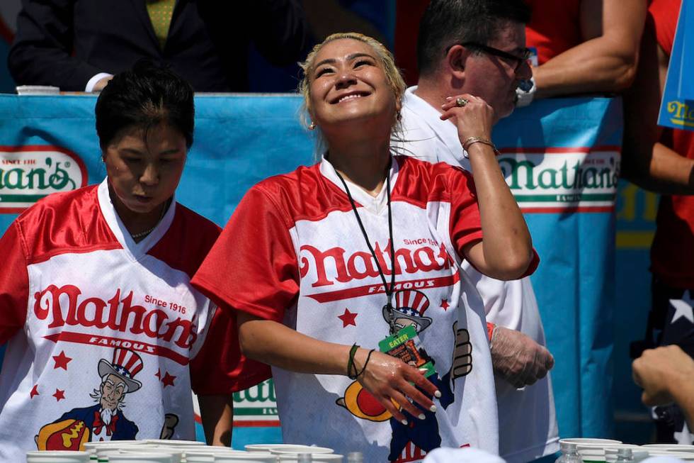 Miki Sudo, right, reacts after eating 31 hot dogs to win the women's competition of Nathan's Fa ...