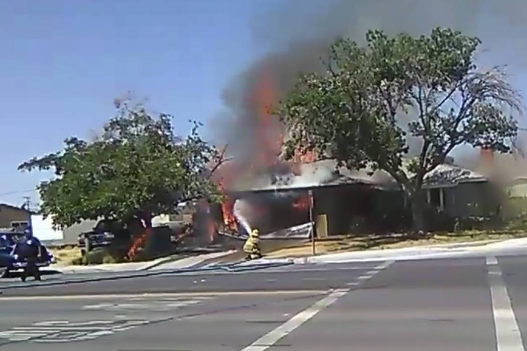 In this image taken from video, a firefighter works to extinguish a fire, Thursday, July 4, 201 ...