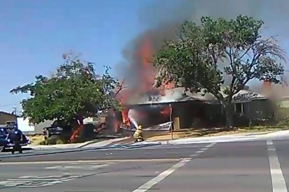 In this image taken from video, a firefighter works to extinguish a fire, Thursday, July 4, 201 ...