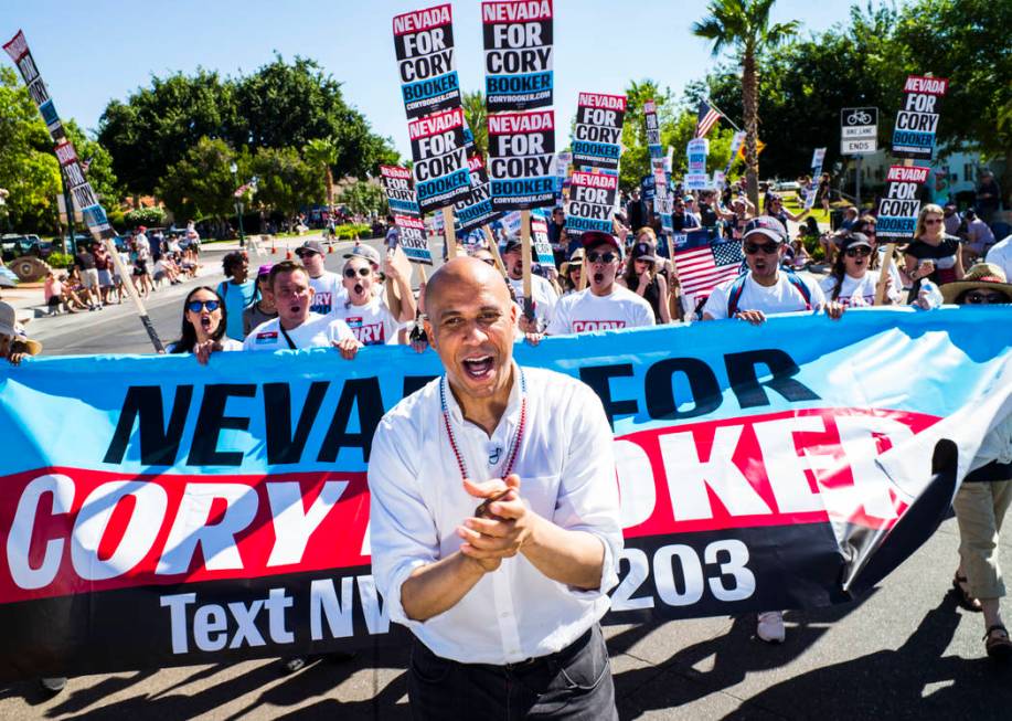 Democratic presidential candidate Sen. Cory Booker, D-N.J., marches with supporters in a parade ...