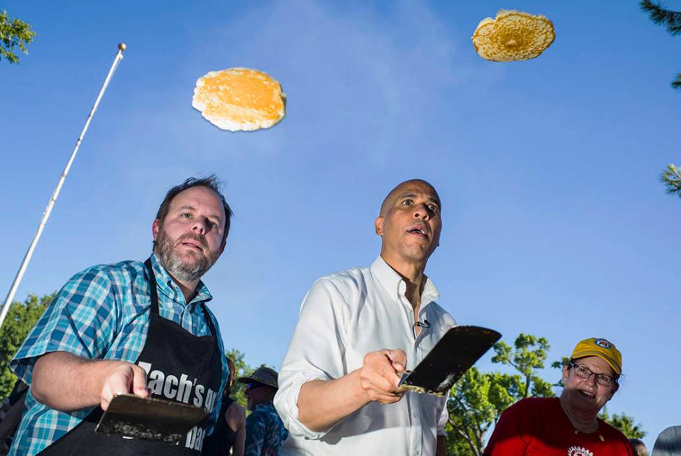 Nevada Treasurer Zach Conine, left, flips pancakes with Democratic presidential candidate Sen. ...