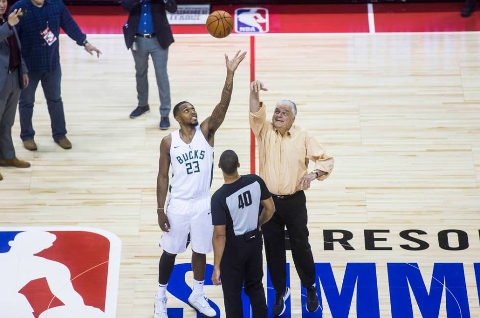 Gov. Steve Sisolak, right, participates in a tip off with Milwaukee Bucks' Sterling Brown (23) ...