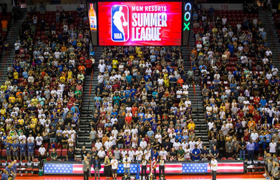 Attendees stand for the national anthem before the start of a basketball game between the Milwa ...