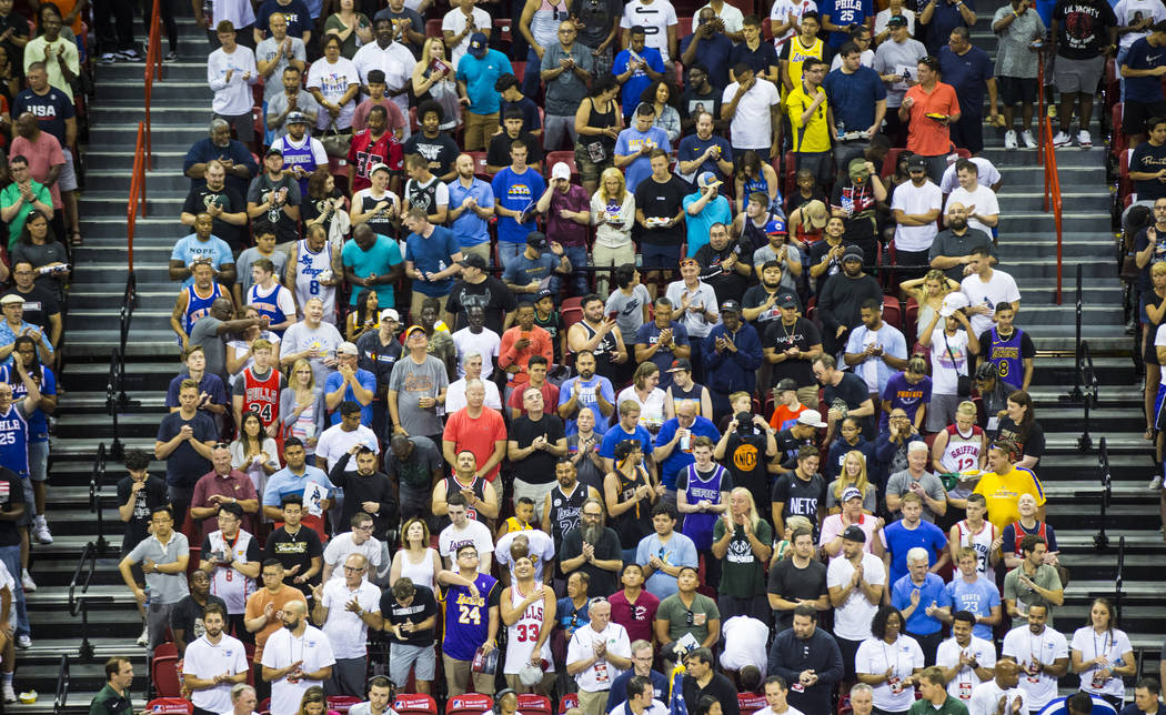 Attendees cheer after the national anthem before the start of a basketball game between the Mil ...