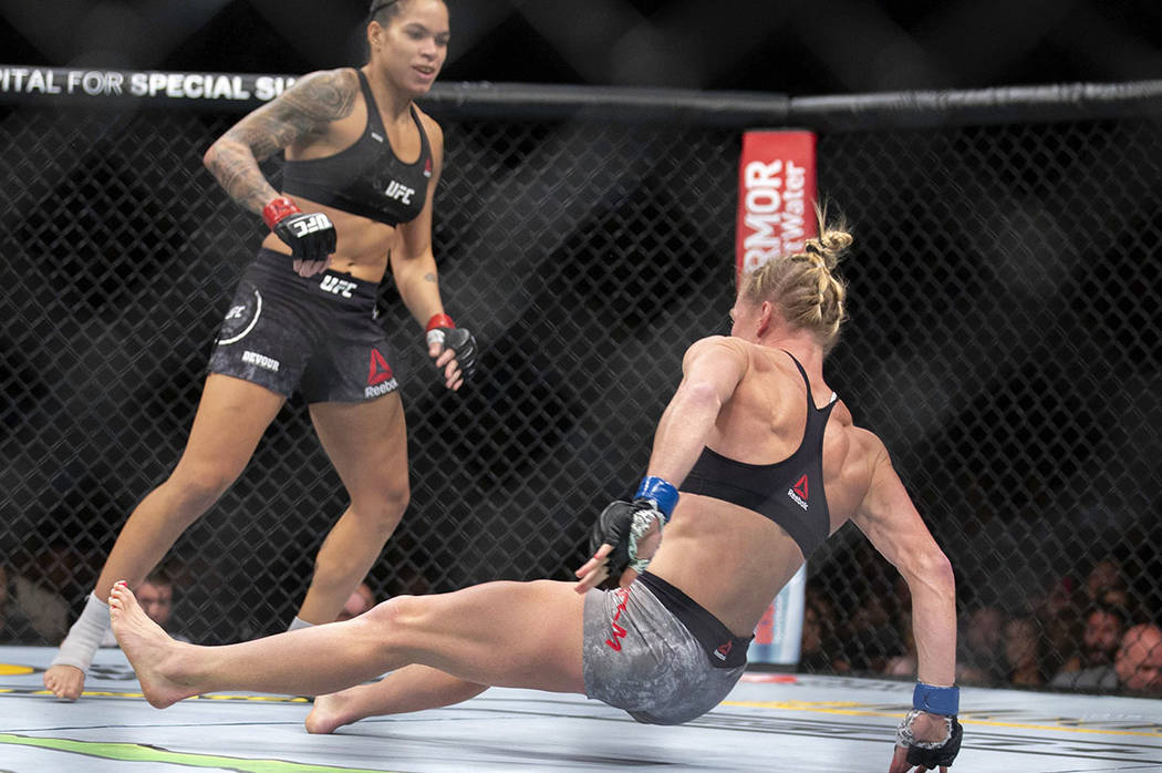 Amanda Nunes, left, knocks out Holly Holm with a kick during the first round of their women's b ...