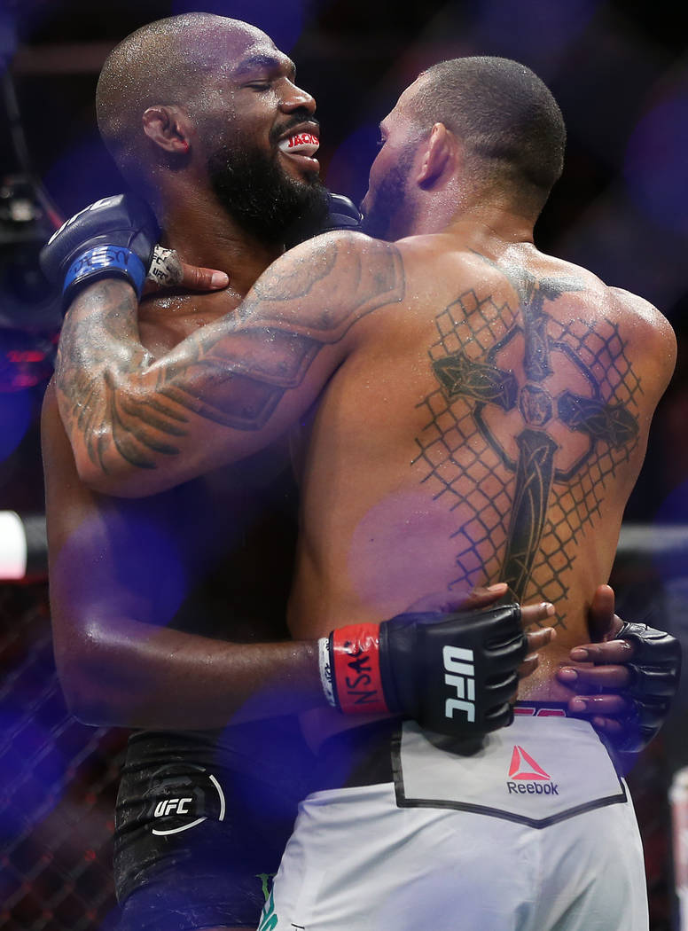 Jon Jones, left, hugs Thiago Santos after Jones won their light heavyweight title bout by split ...