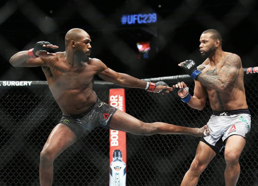 Jon Jones, left, lands a kick against Thiago Santos in the fourth round during their light heav ...