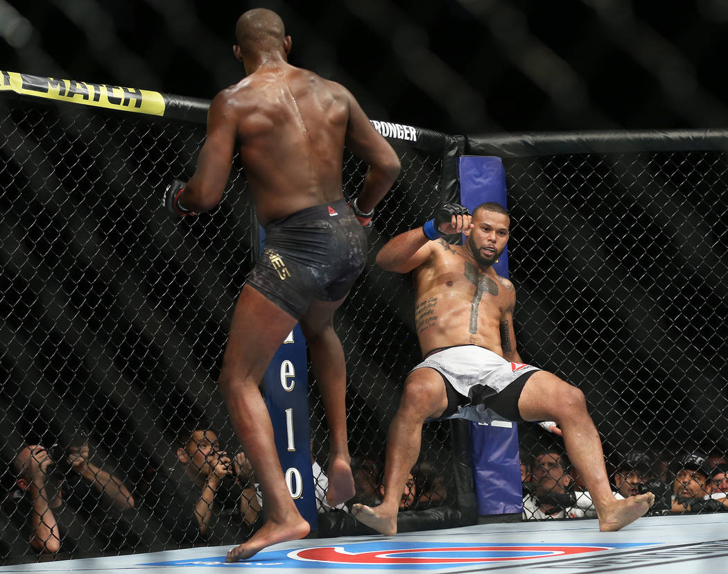 Jon Jones, left, knocks down Thiago Santos in the fourth round during their light heavyweight t ...