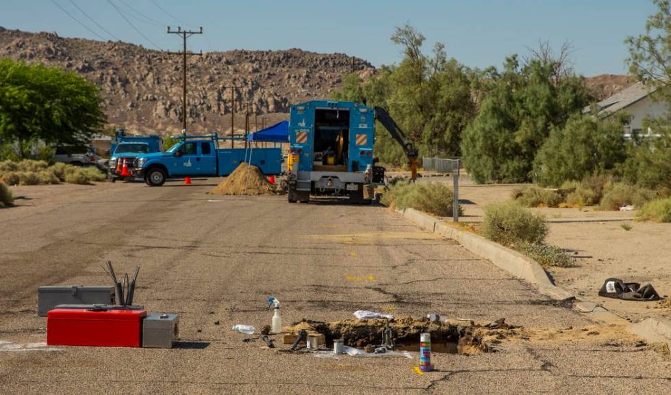 An open hole revealing a broken gas line is repaired by a PG&E crew in Trona, CA., due to t ...