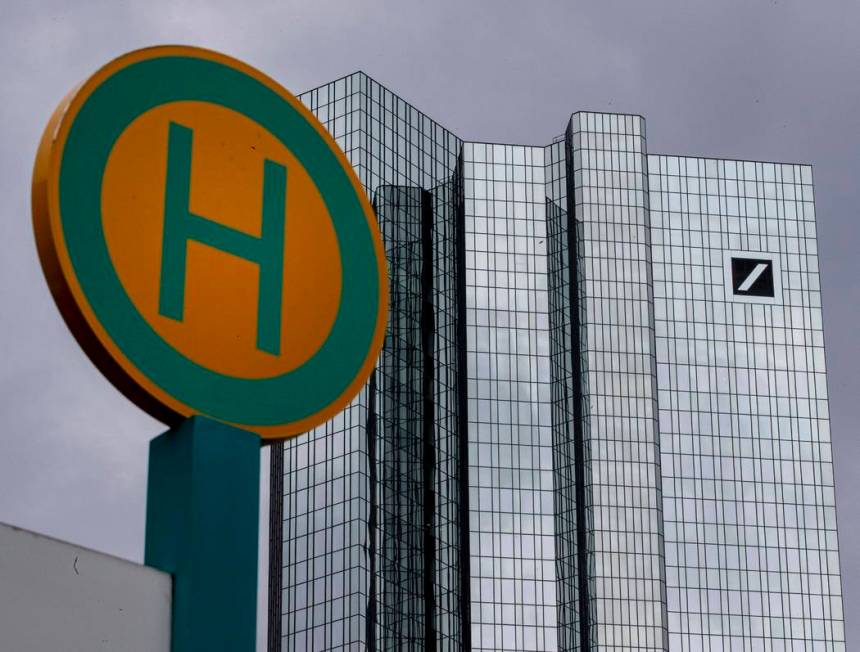 The headquarter of Deutsche Bank is seen next to a bus stop sign in Frankfurt, Germany, Sunday, ...