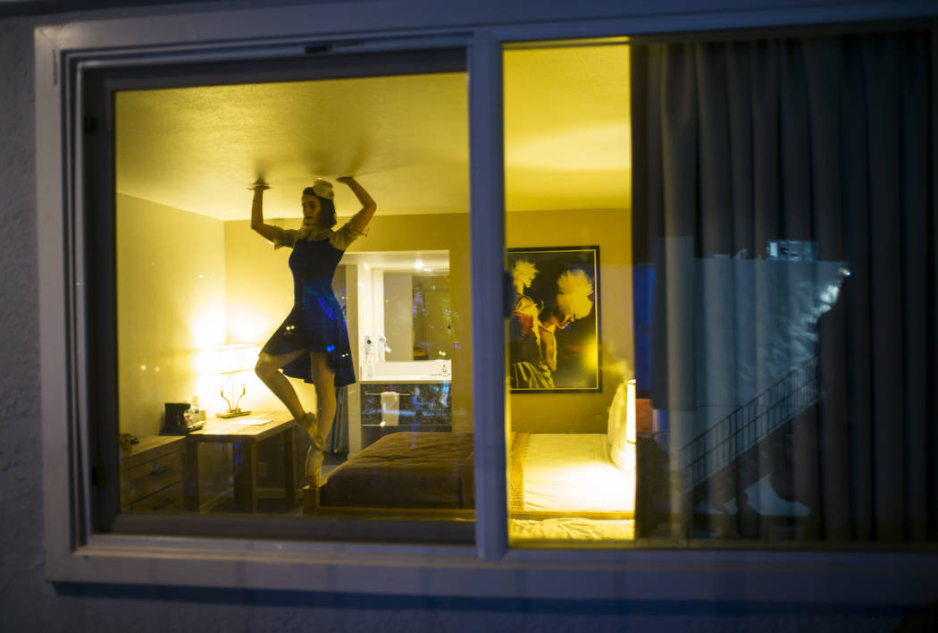 A performance artist stands at the edge of a bed in a room during the Jack Daniel's House No. 7 ...